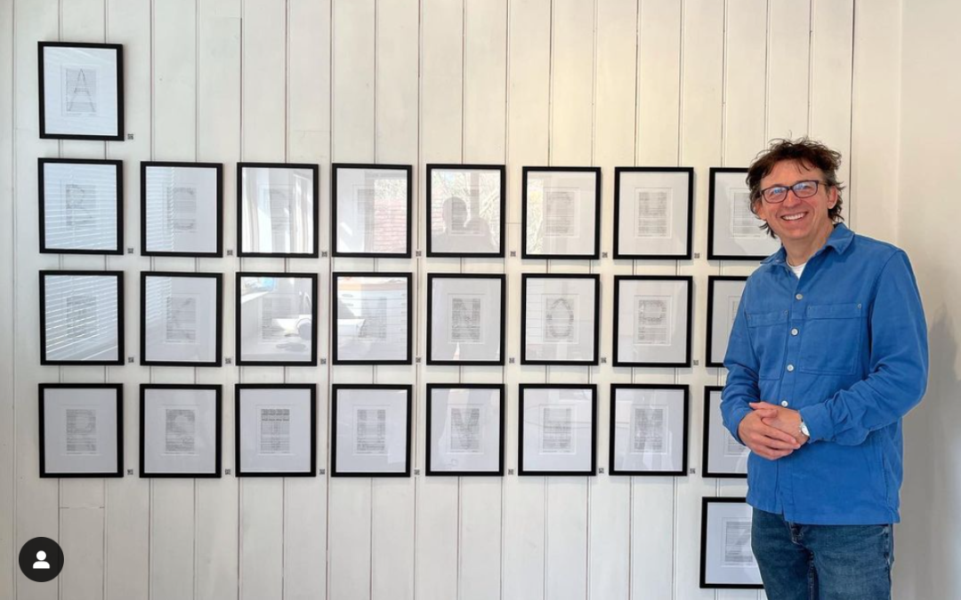 Will Todd in front of a row of framed letters from the Symphony of Letters